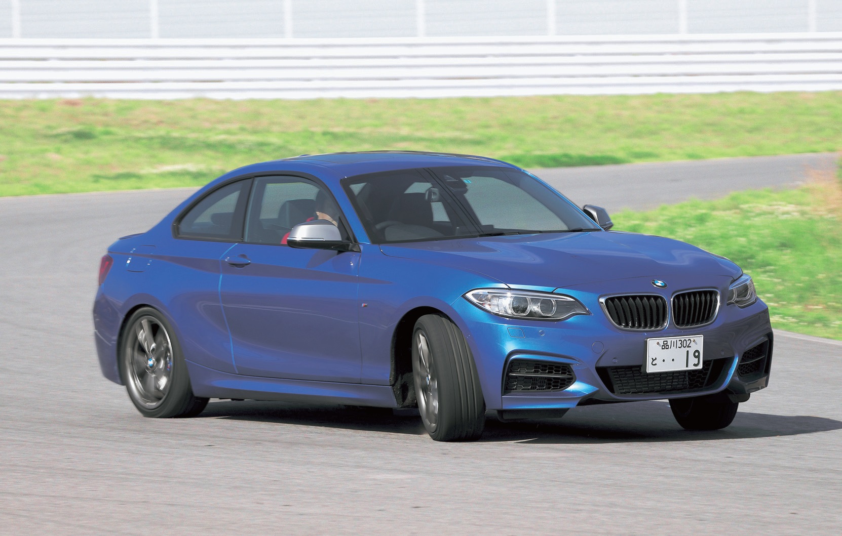 BMW M235iクーペ:エンジンやブレーキに冷却用空気を供給する大型エアインテークを備えた専用フロントエプロンやフェリックグレーのドアミラー、専用セットアップされたアダプティブMサスペンション(電子制御式ダンパー)やステアリングギアレシオを可変制御するバリアブルスポーツステアリング、対向ピストン・ブレーキキャリパーを備えたMスポーツブレーキなど専用装備が満載