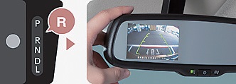 燃費改善に加え、予防安全技術「e-Assist」も搭載　衝突被害軽減ブレーキ「e-Assist」を搭載。約5アイドリングストップ機能の改善で燃費が最大1.8km／Lの向上となった～30km／h走行時にレーザー（写真右）が、前方車両を検知し自動ブレーキを作動させる。またルームミラーにリア映像を映す機能もある（写真左）