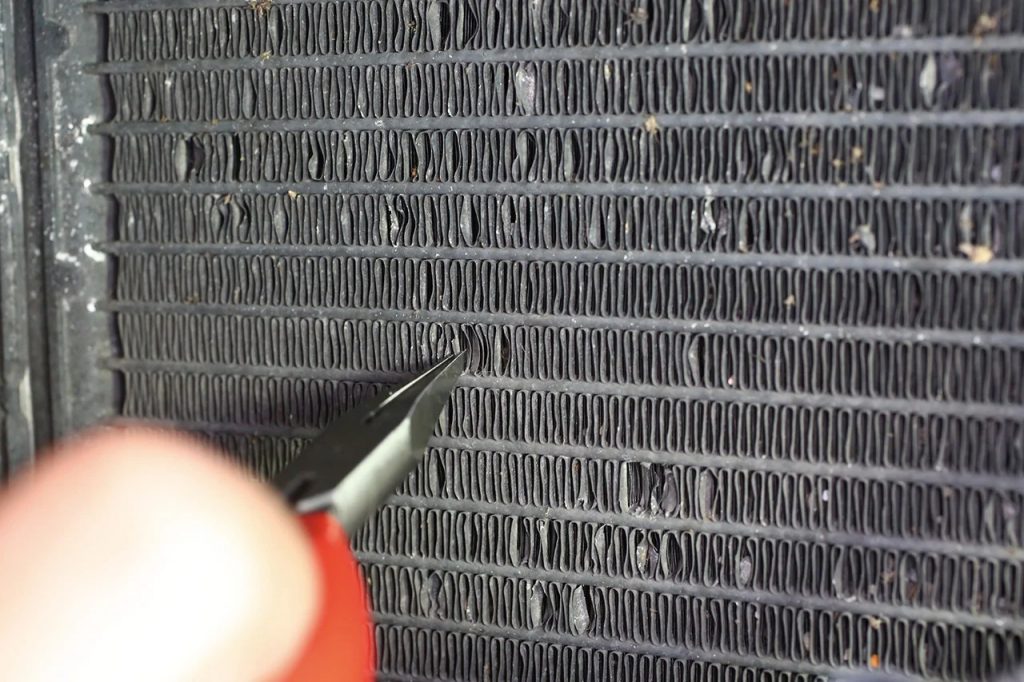 フィンの曲がり修正。コンデンサーはフィンのピッチが狭いので、ビル用エアコンで使うようなフィン修正ツールでは修正ができない。